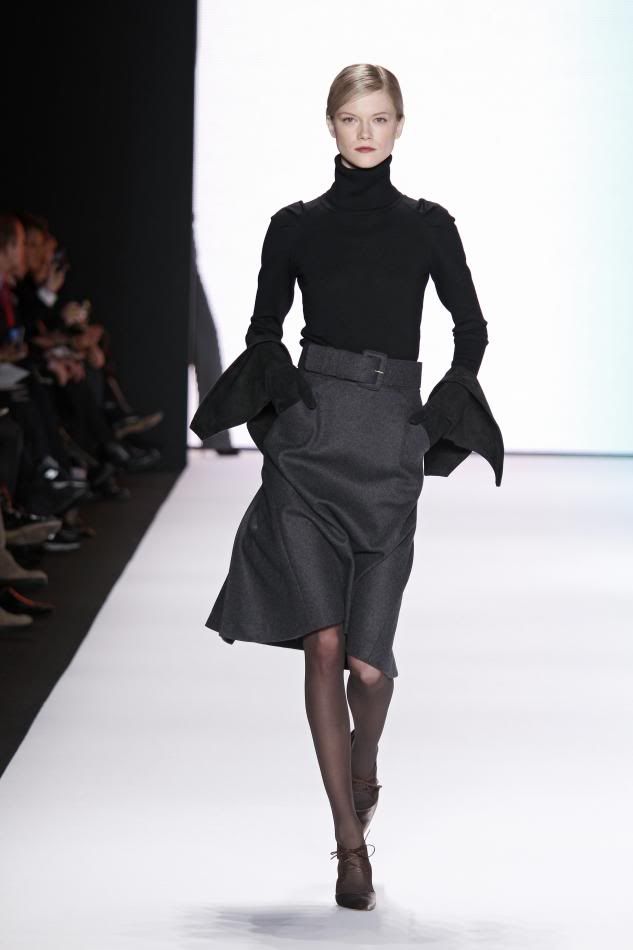 2. Kasia Struss:Dark gray wool flannel wing skirt, black cashmere turtleneck, dark gray velvet belt, black suede gloves